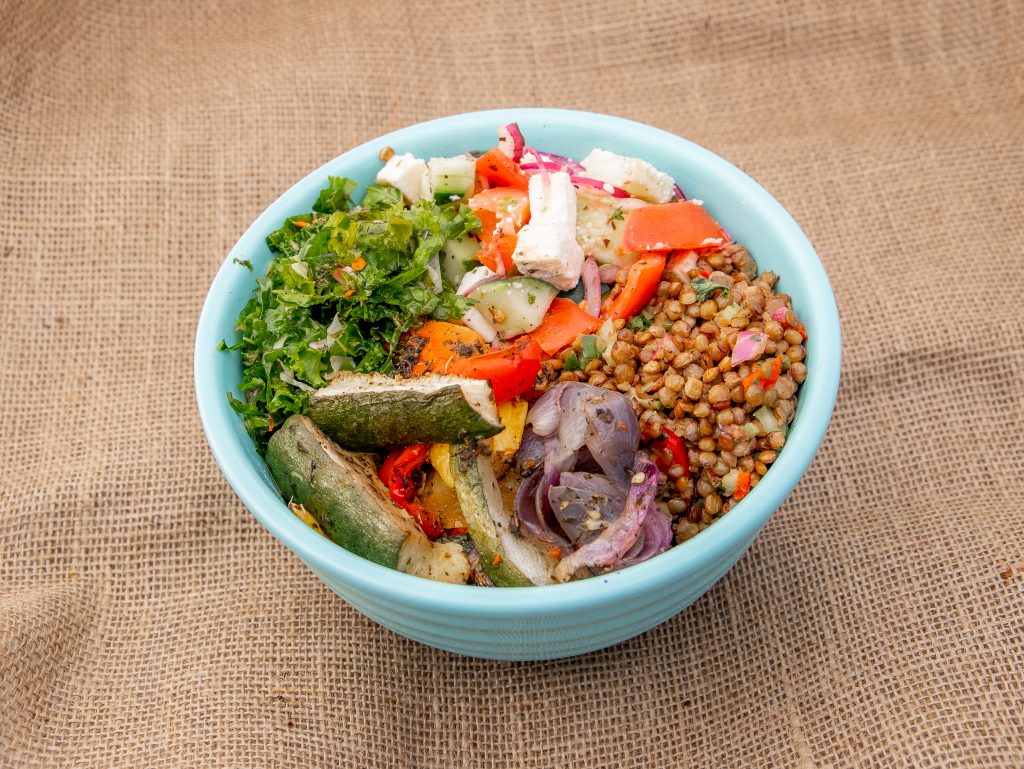 Greek salad bowl with veggies on table