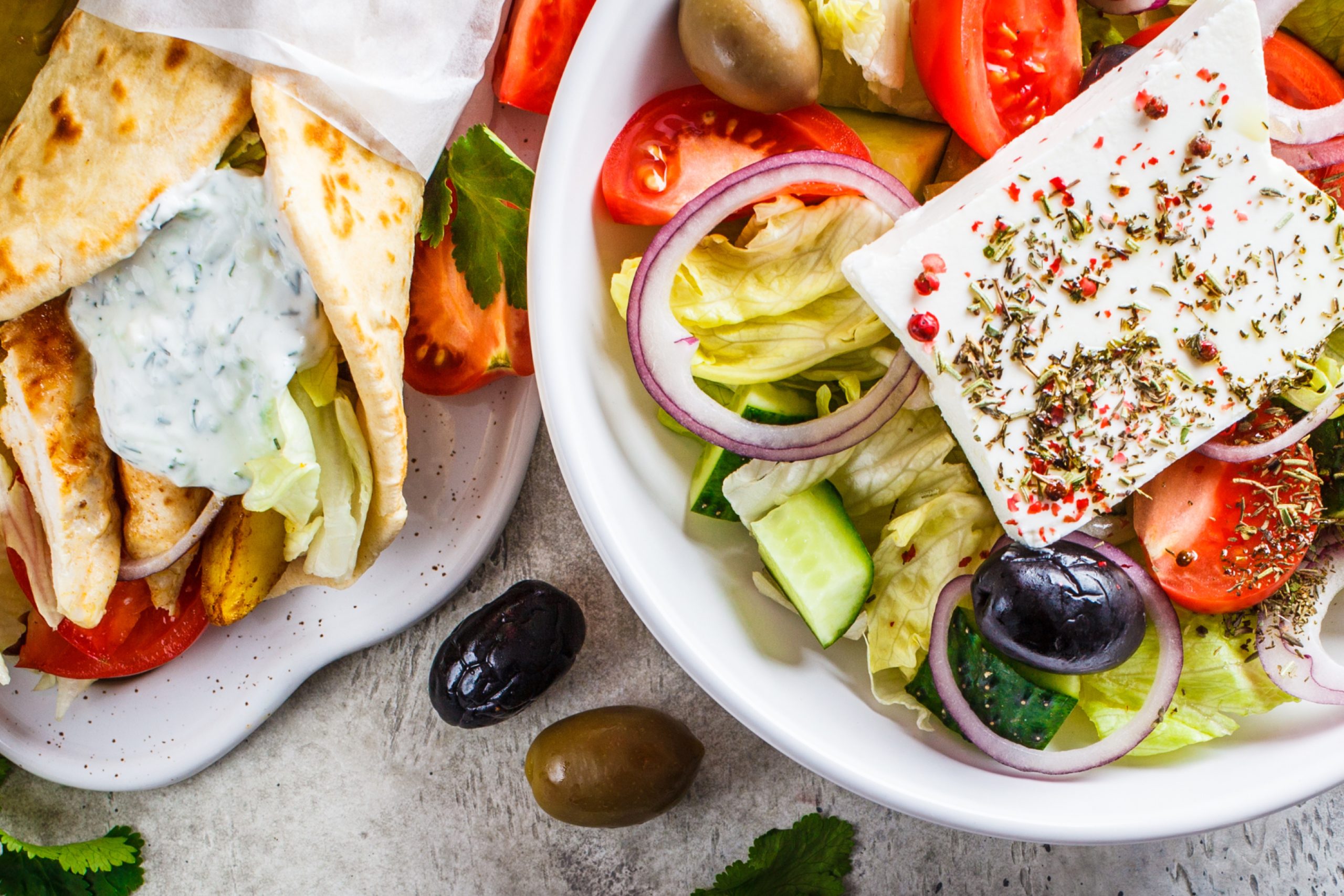 Closeup of Greek salad and Greek chicken pita wrap